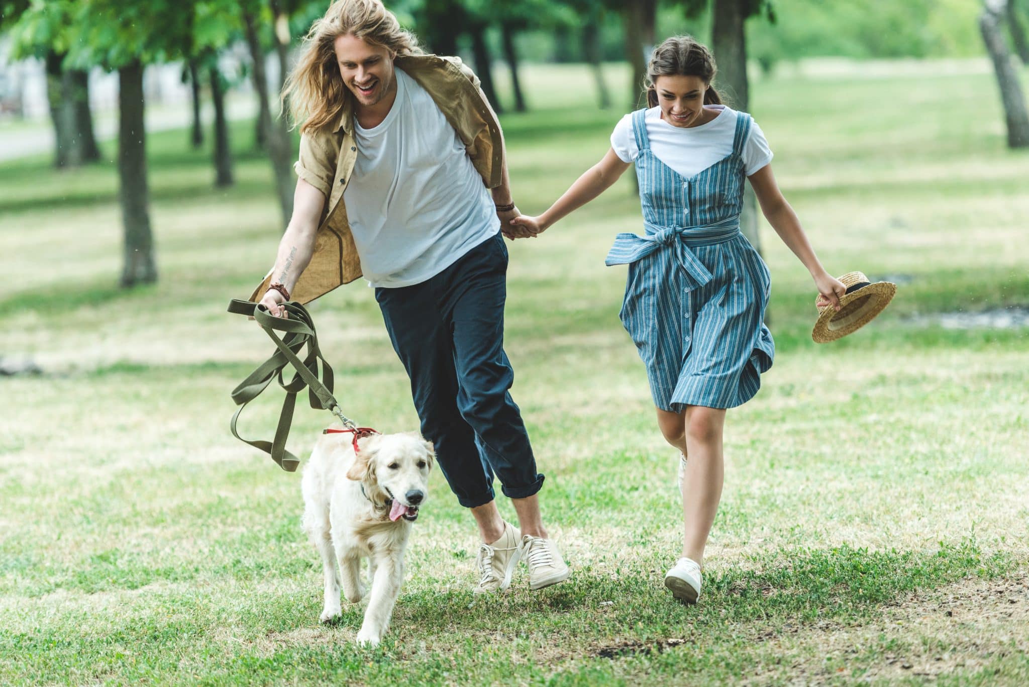 Young couple playing with thier dog in a Maitland park